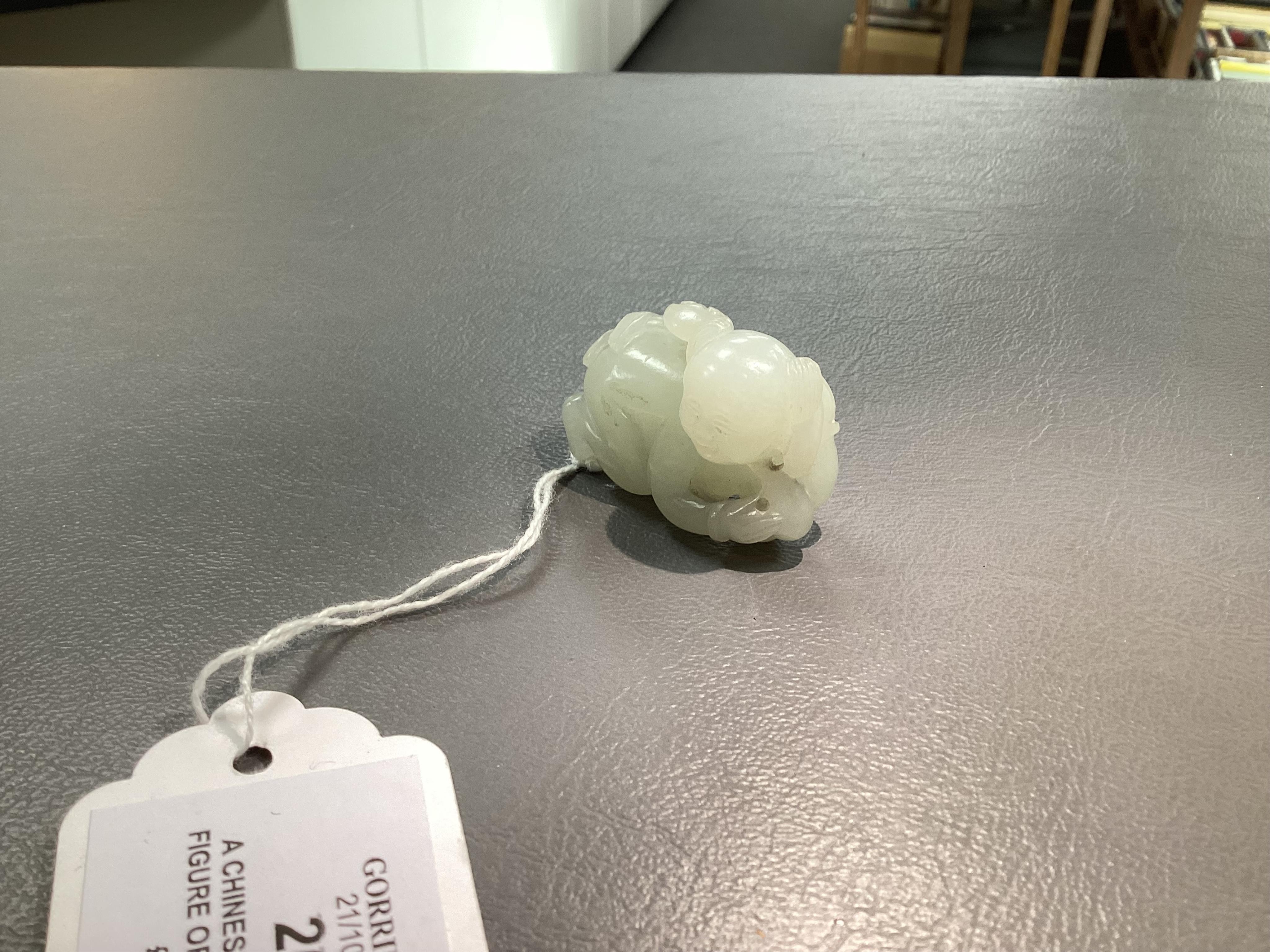 A Chinese white jade figure of a crouching boy, 19th/20th century